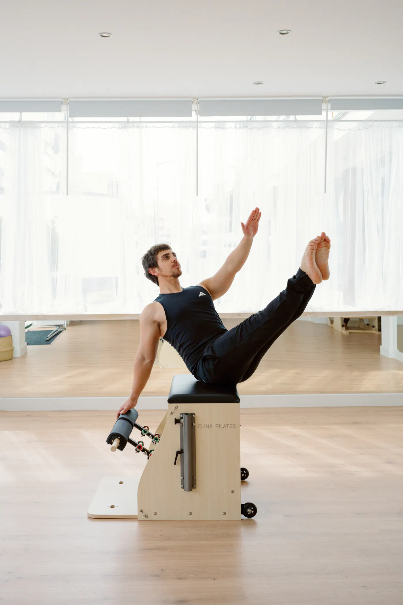Aluno a executar um exercício na cadeira de Pilates